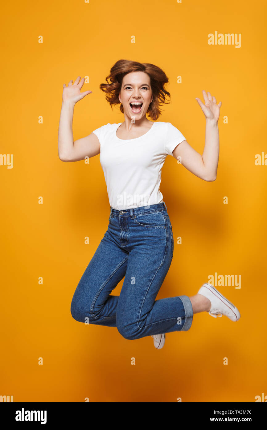 Full length portrait of a happy lovely girl jumping isolated over ...