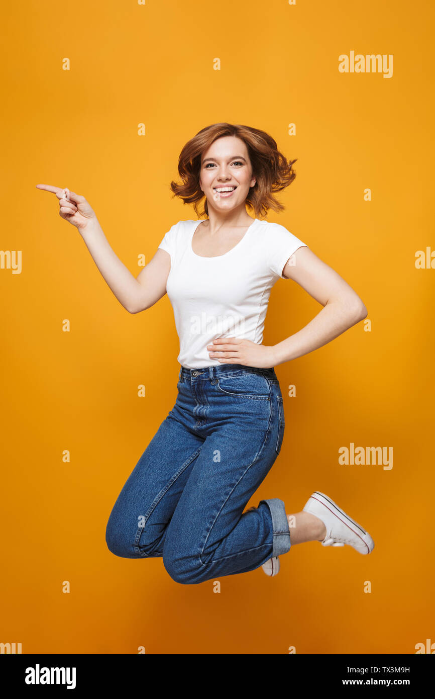 Full length portrait of a happy lovely girl jumping isolated over ...