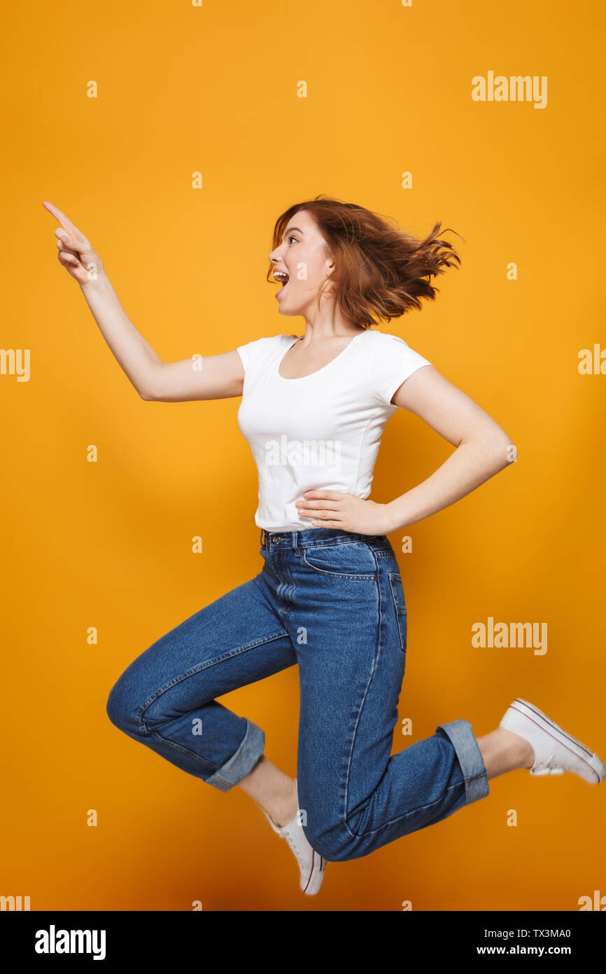 Full length portrait of a happy lovely girl jumping isolated over ...