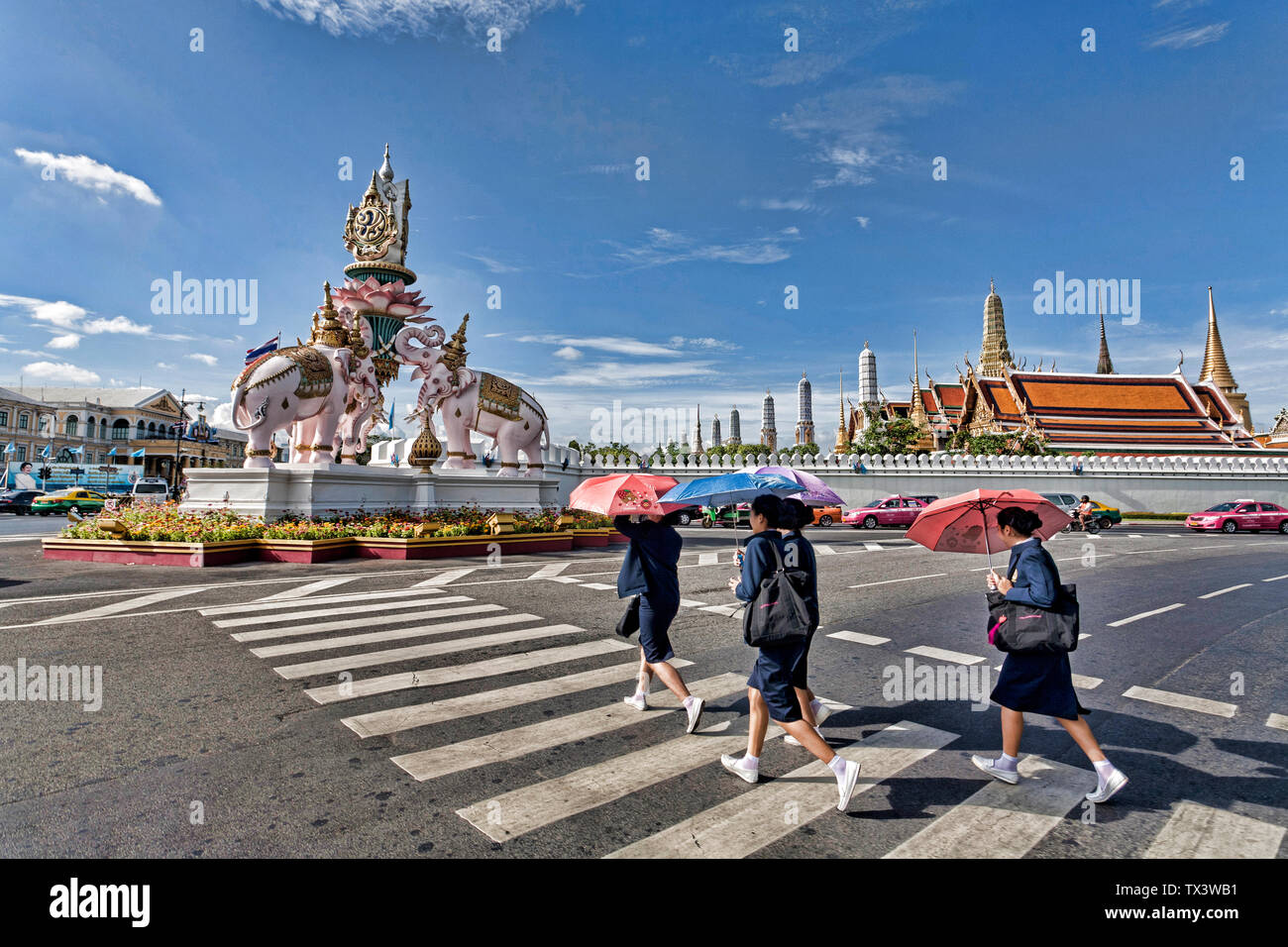 Schoolgirls crossing the road at Three Elephants statue Bangkok Thailand Stock Photo