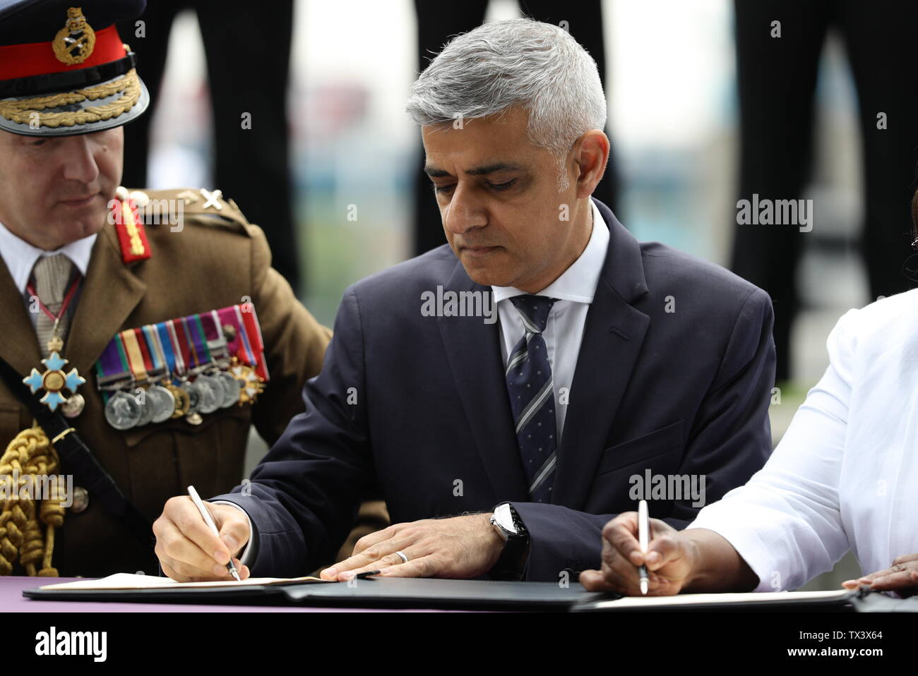 Mayor of London Sadiq Khan signs the Armed Forces Covenant during a flag-raising ceremony at City Hall, London, to show support for the men and women who make up the Armed Forces community ahead of Armed Forces Day. Stock Photo