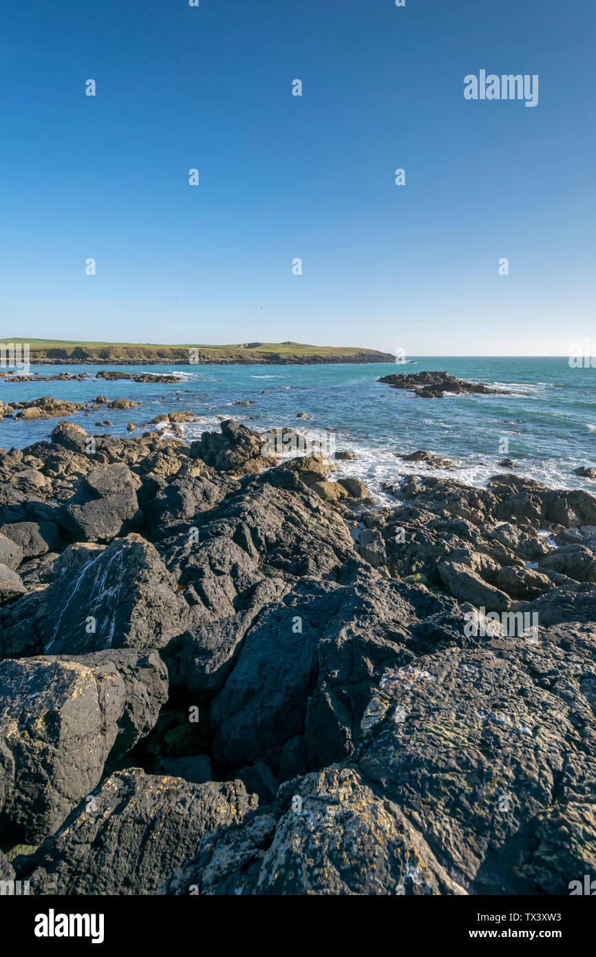 Porth Nobla near Rhosneigr on Anglesey North Wales UK looking towards the Chambered cairn Barclodiad y Gawres Stock Photo