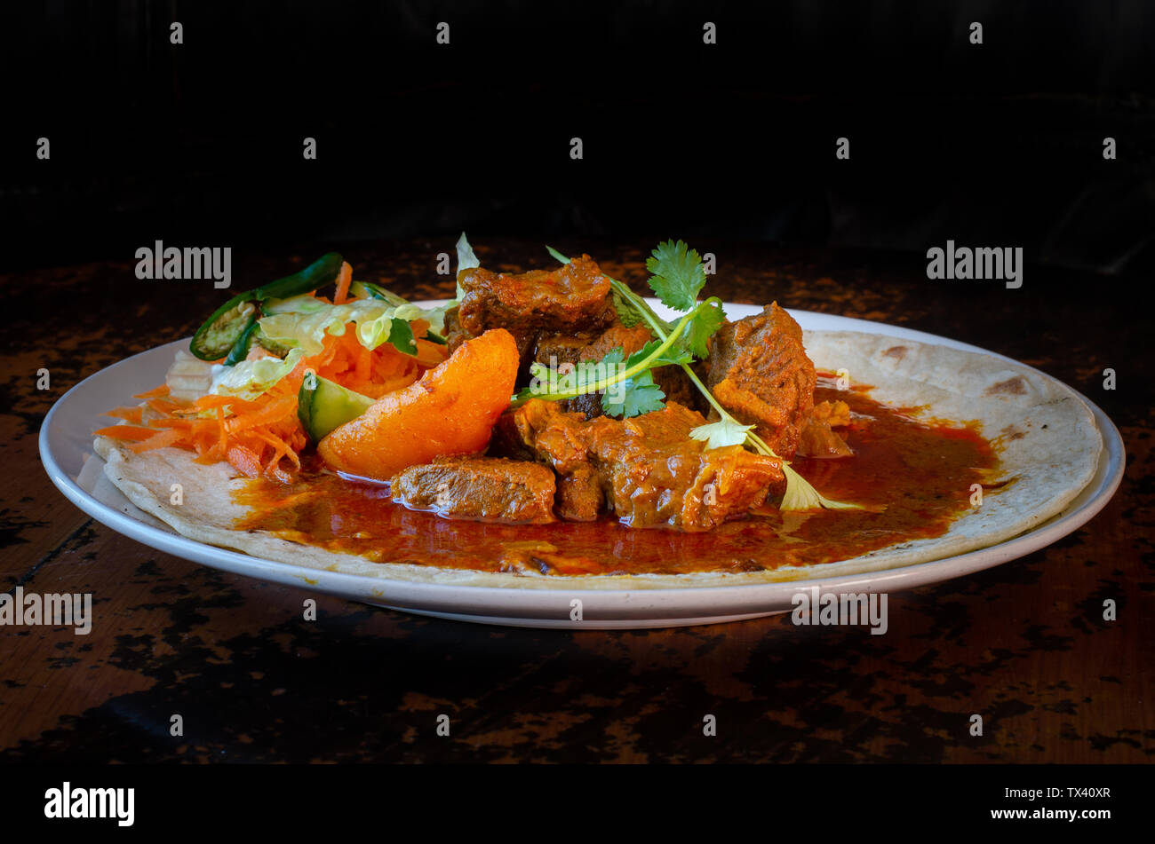 A mutton curry roti with sambals - an iconic Durban meal consisting of ...