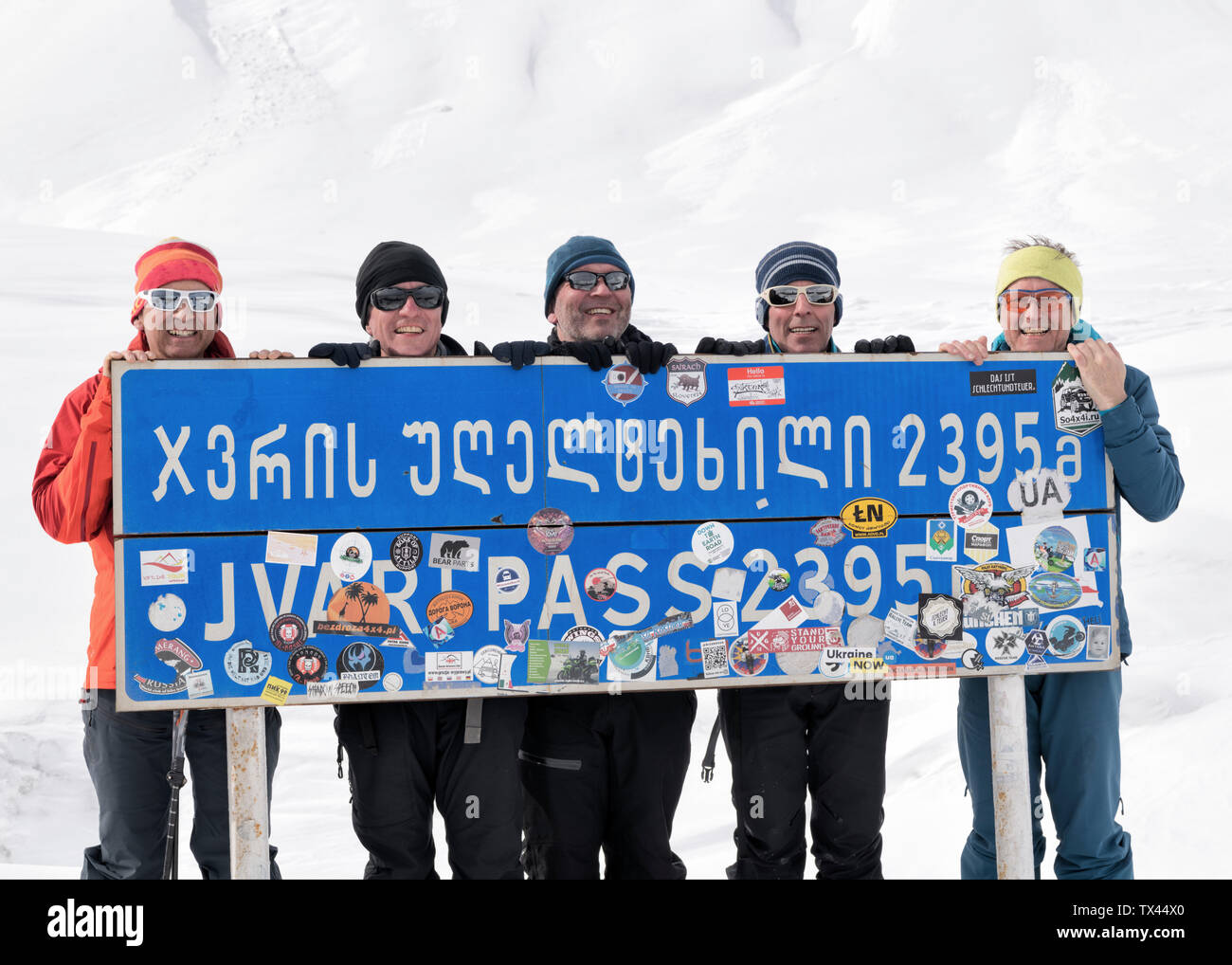 Georgia, Caucasus, Gudauri, portrait of happy ski tourers holding a sign Stock Photo