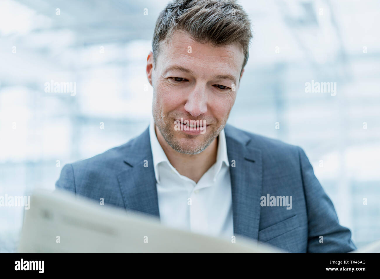 Portrait of businessman reading newspaper Stock Photo