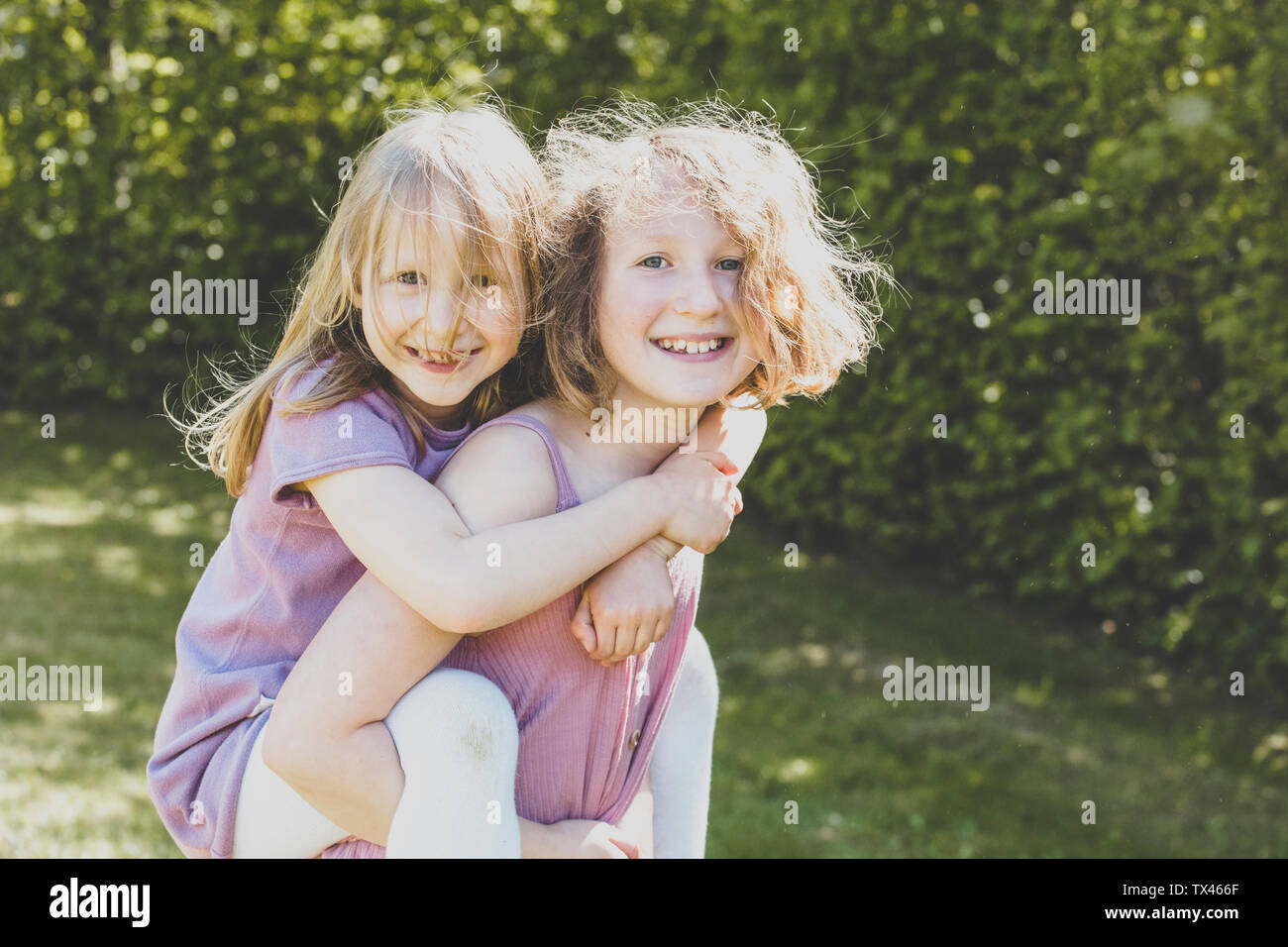 A big sister carrying her small sister, Girl power Stock Photo