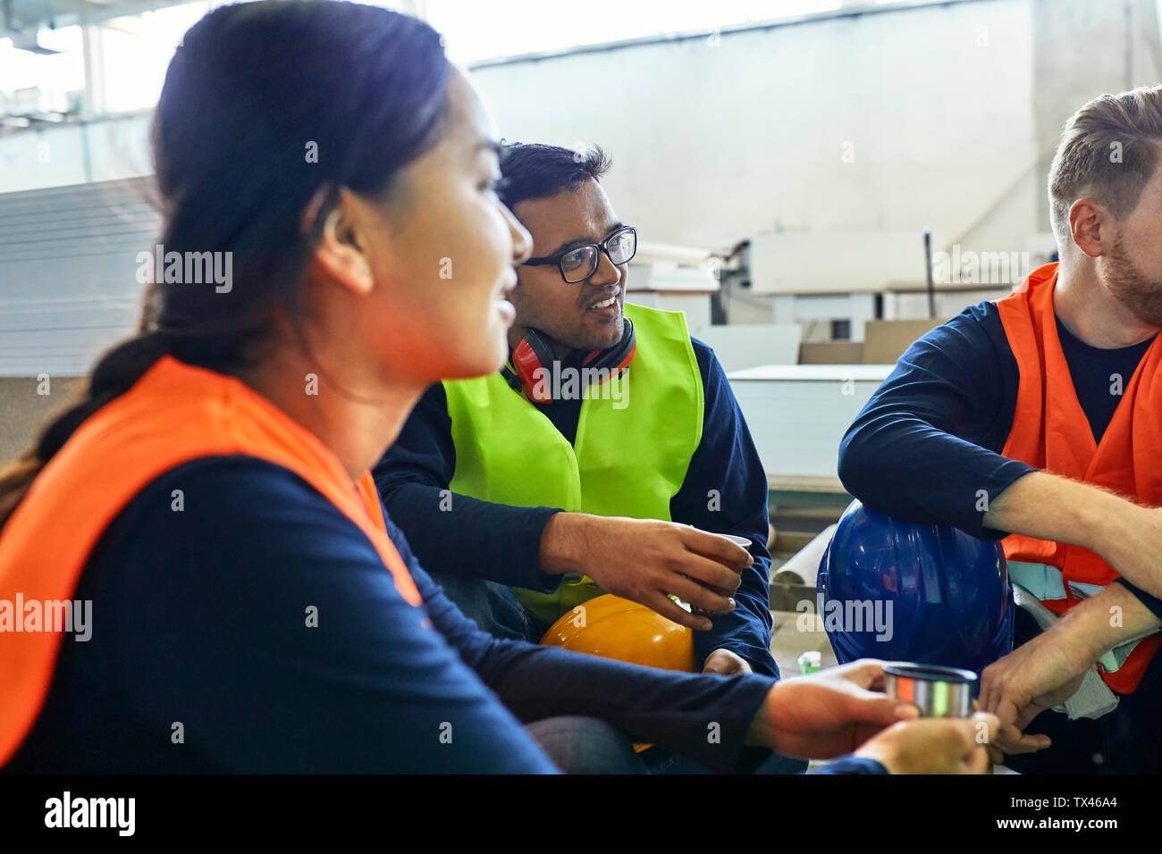 Workers in factory having lunch break together Stock Photo