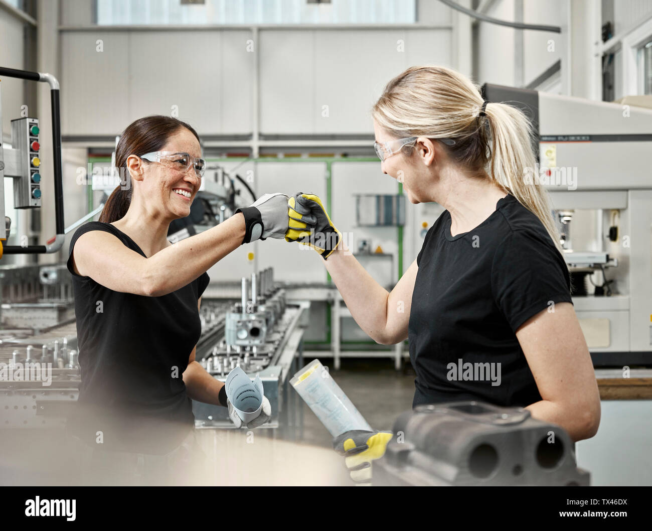 Two woman at work, fist bump Stock Photo