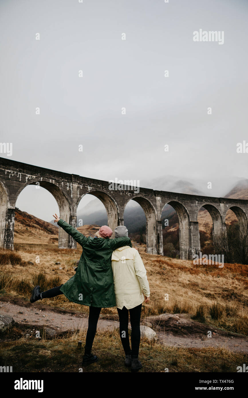 UK, Scotland, Highland, Glenfinnan Viaduct, rear view of female friends looking at view Stock Photo