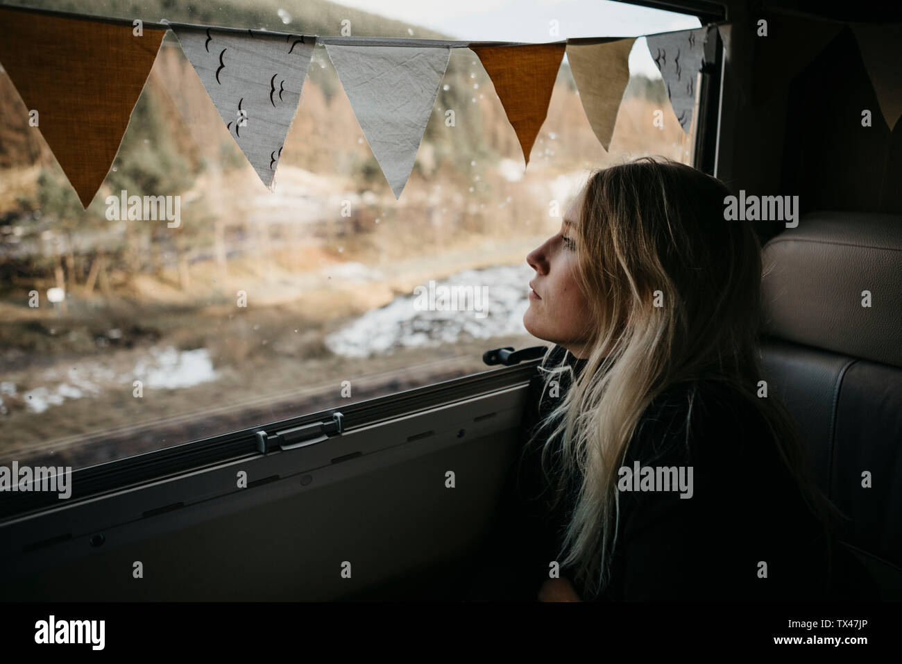 Pensive young woman looking out of car window Stock Photo