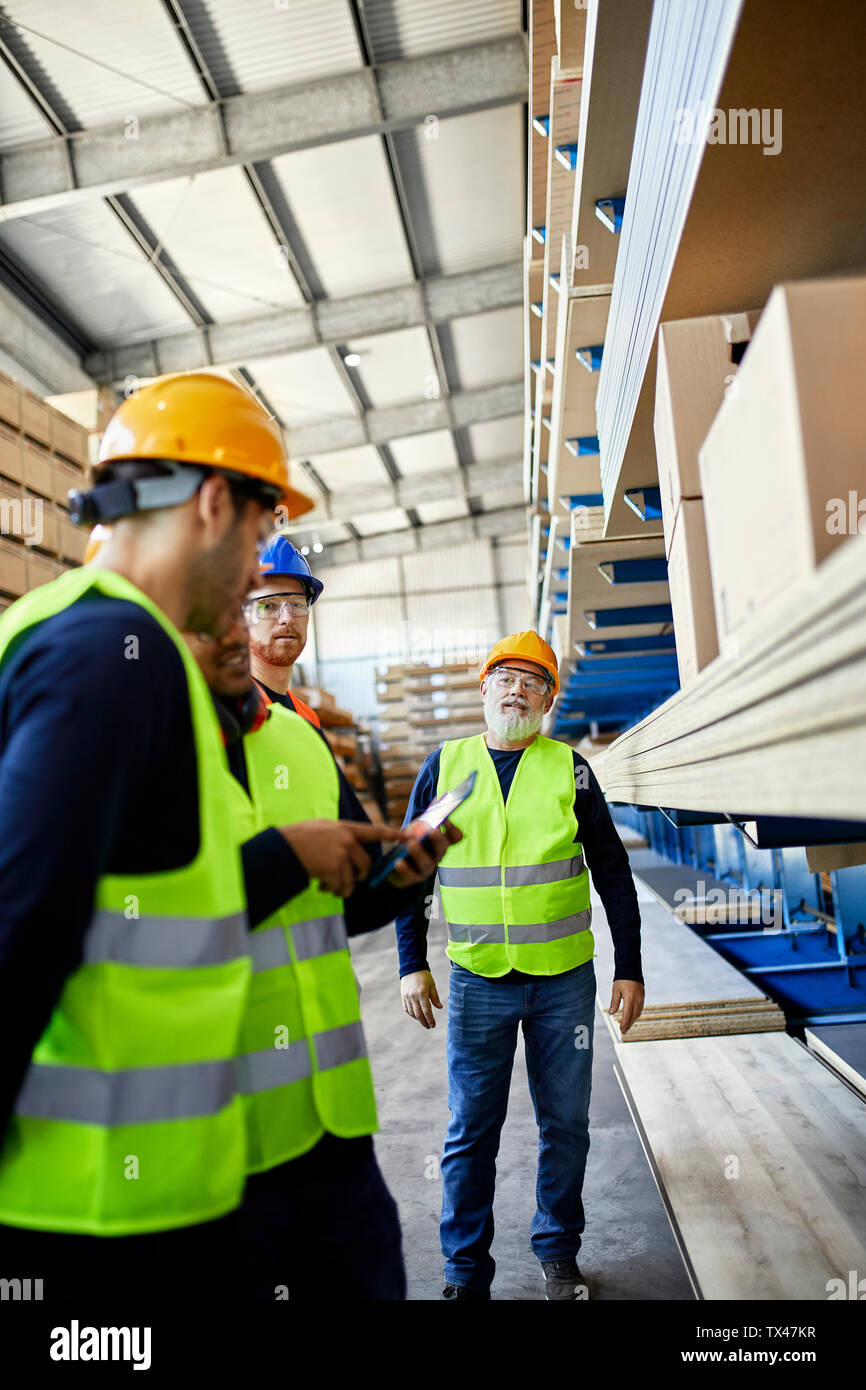 Workers talking in factory warehouse Stock Photo