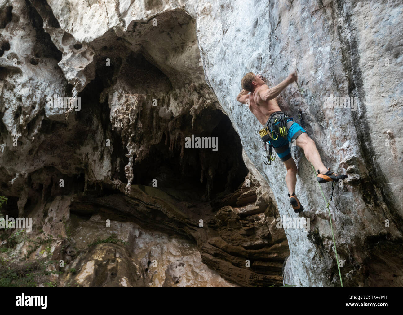 Thailand, Krabi, Railay Beach, barechested climber in rock wall Stock Photo
