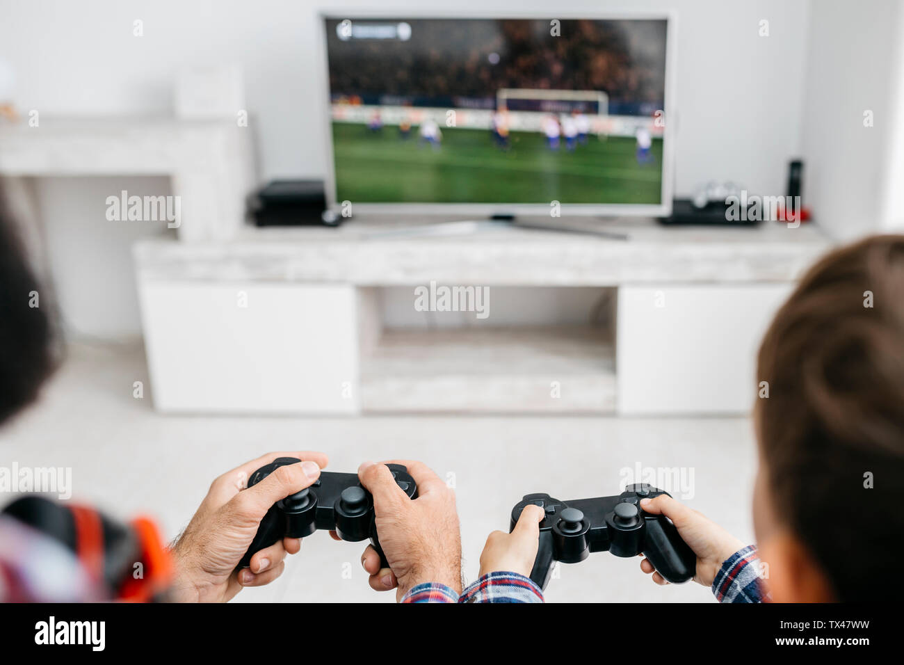 Father and son playing computer game together at home hires stock