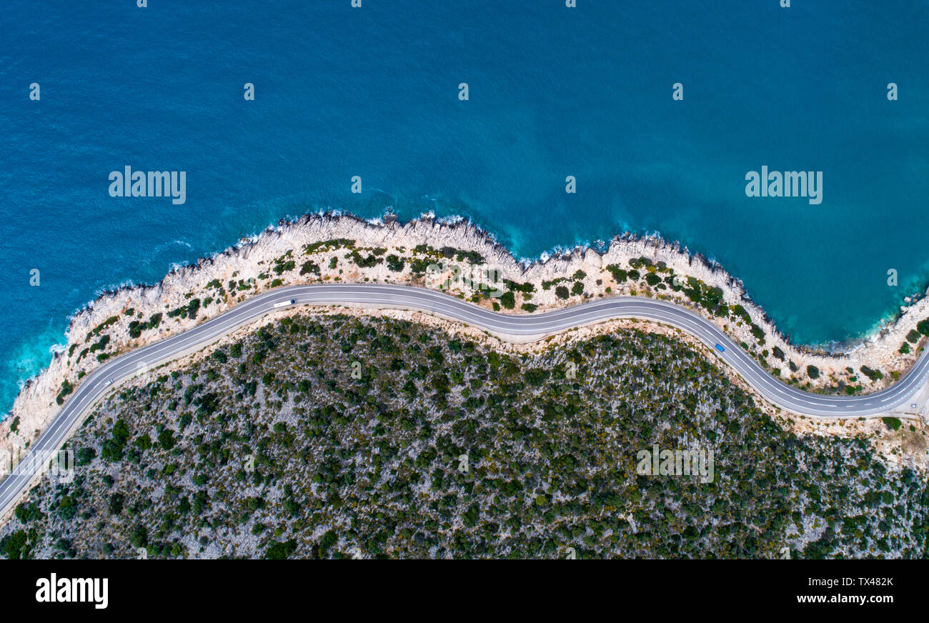 Aerial landscape of coastline and a road seascape. Car drives down the empty asphalt road running along the sunny Mediterranean shoreline of Turkey. T Stock Photo