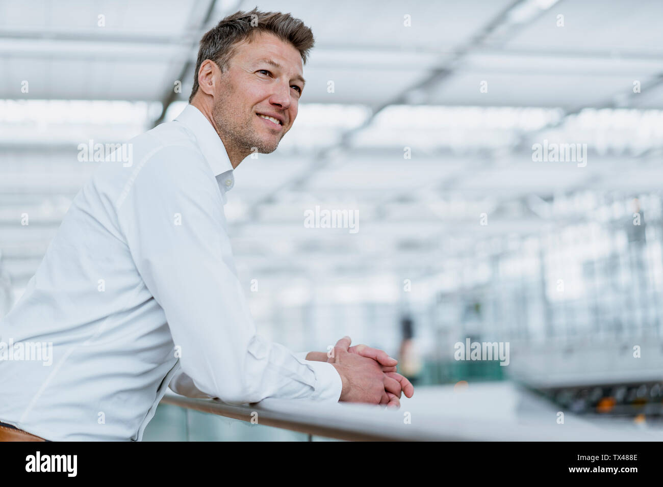 Smiling businessman leaning on railing Stock Photo