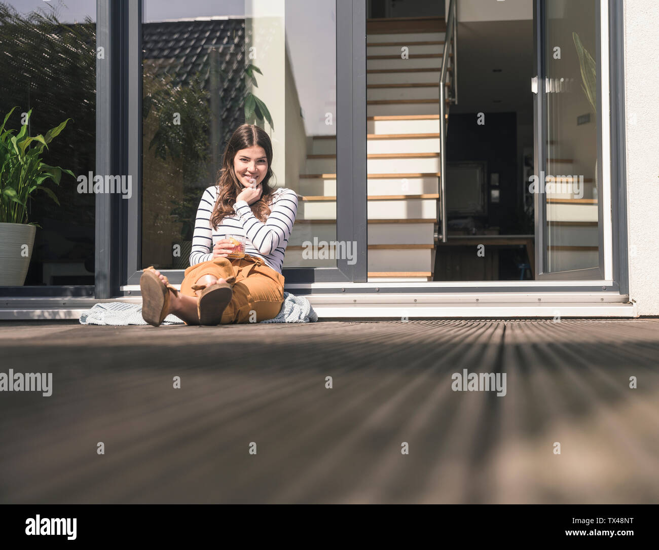Young woman sitting on terrace hi-res stock photography and images - Alamy