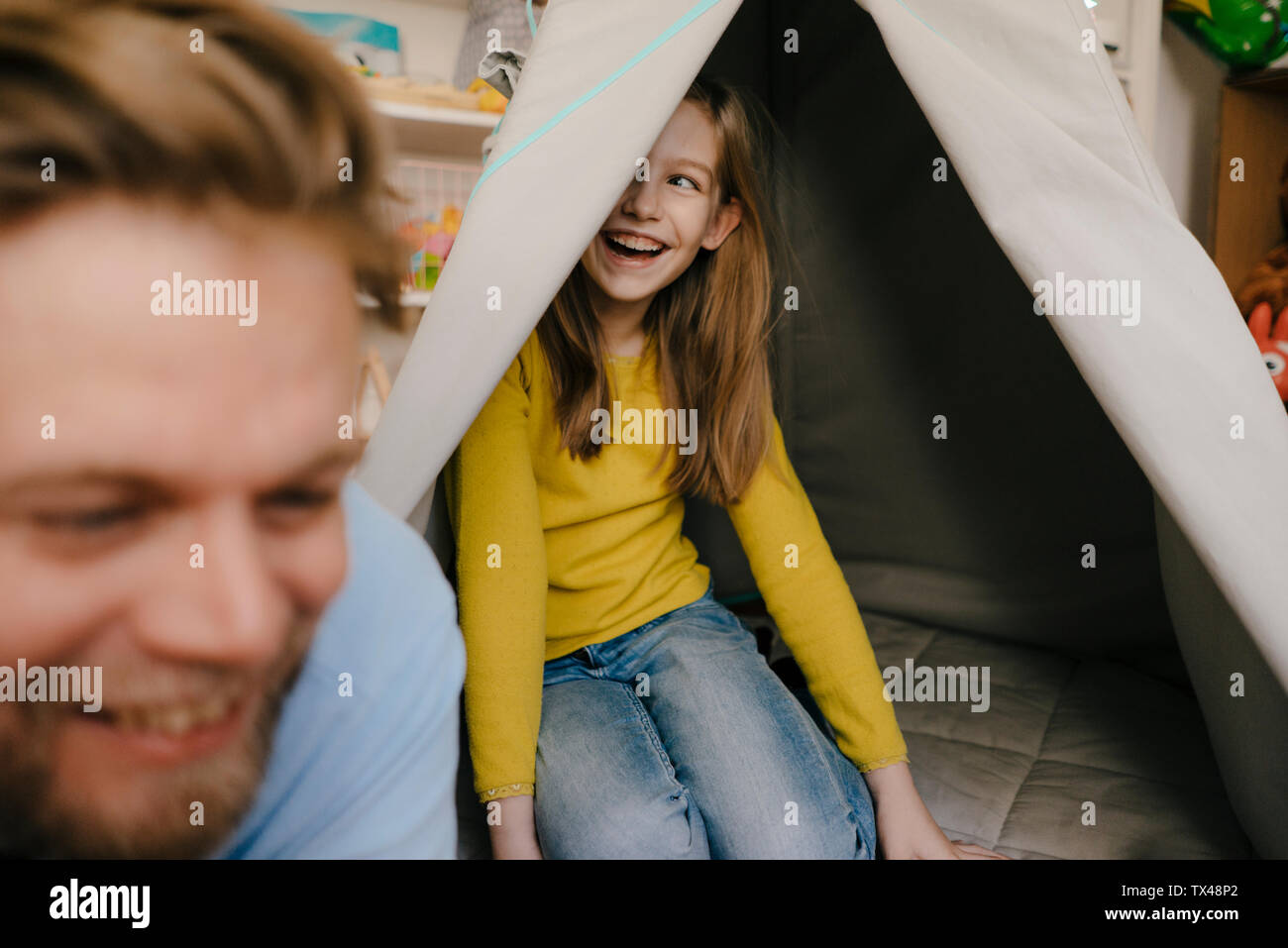 Happy father and daughter with teepee in children's room Stock Photo