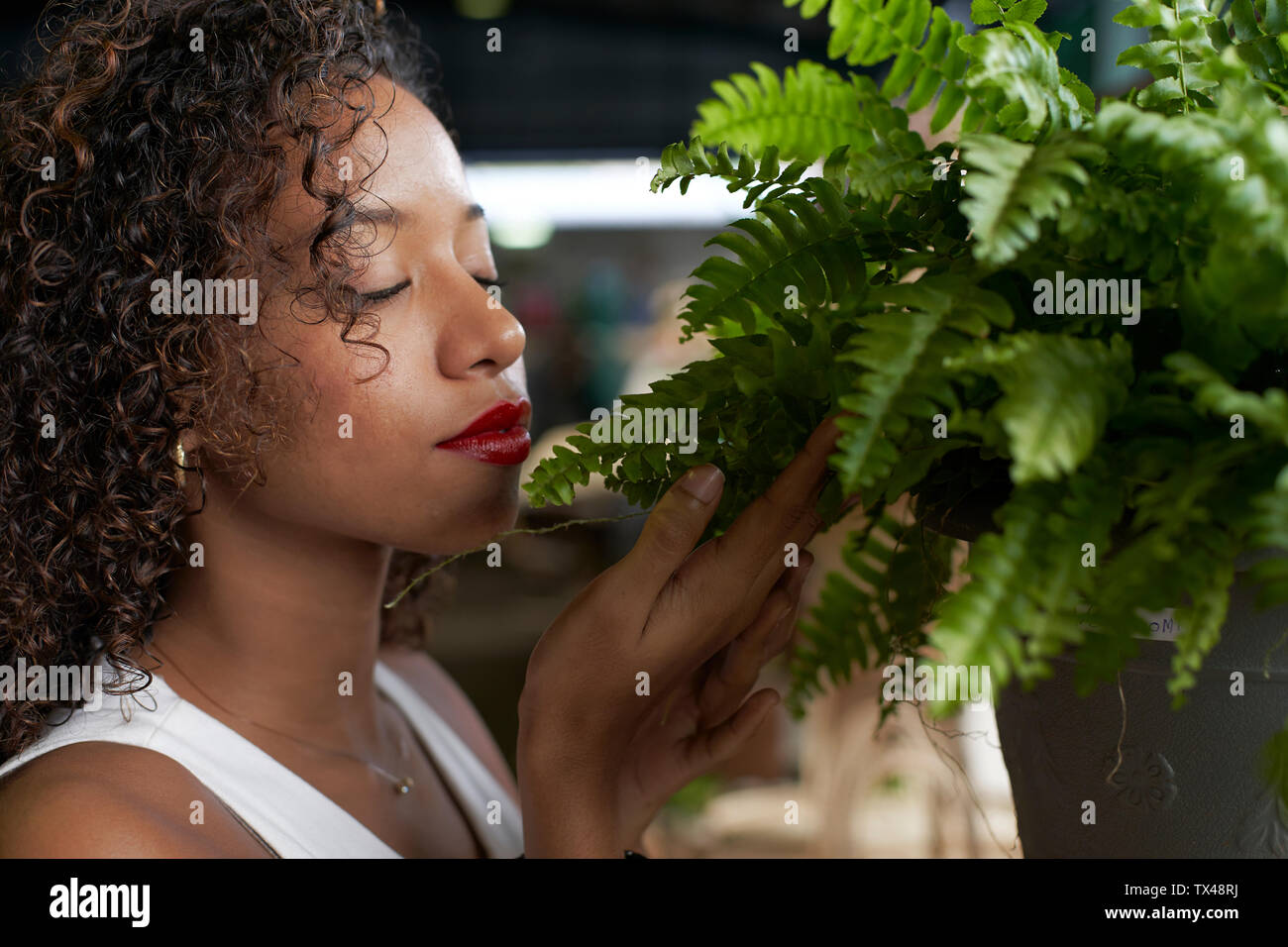 Young woman smelling fern Stock Photo