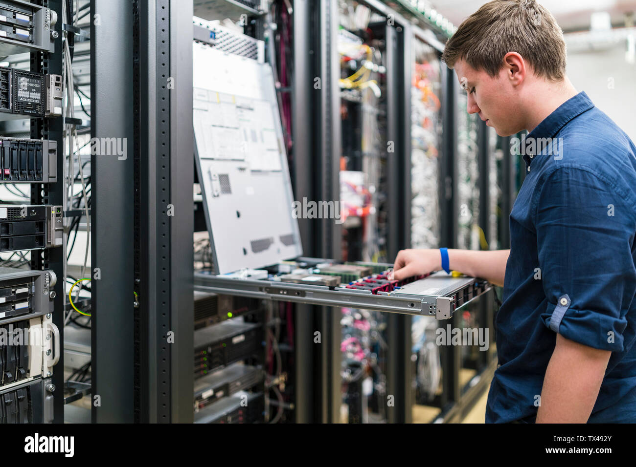 Teenager working in server room Stock Photo