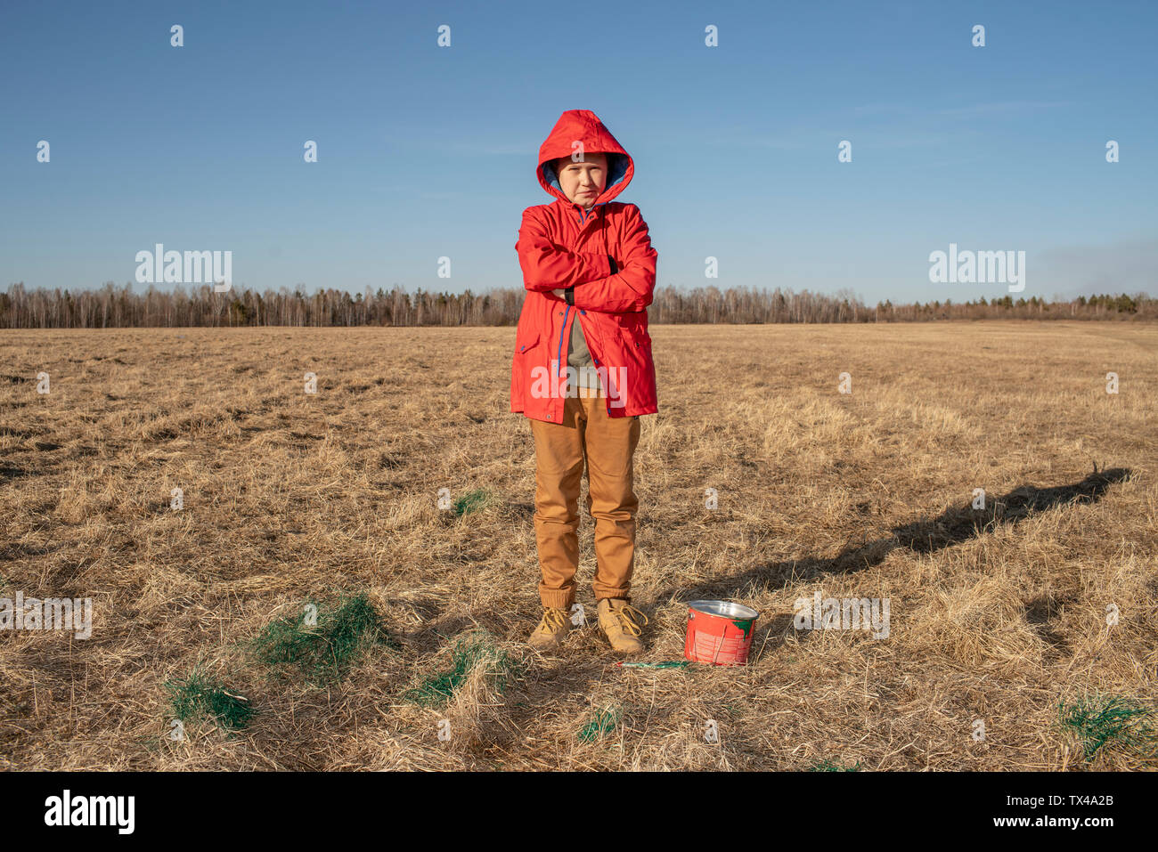 Serious boy with paint bucket in steppe landscape Stock Photo