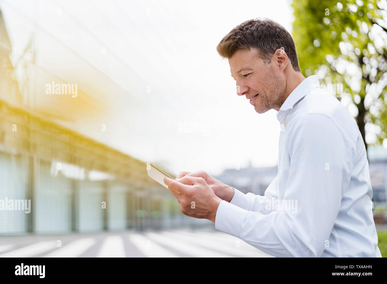 Businessman using tablet outside in the city Stock Photo - Alamy