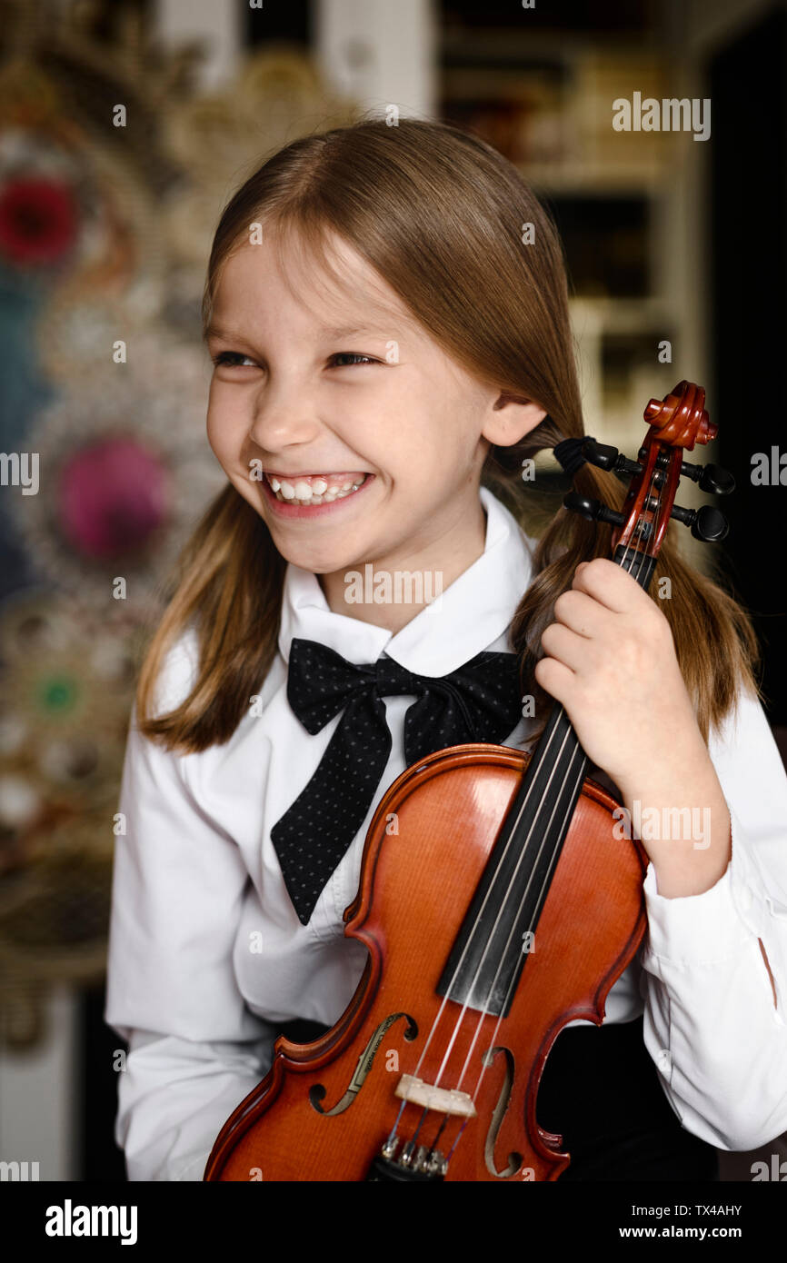 Portrait of a happy girl with a violin at home Stock Photo