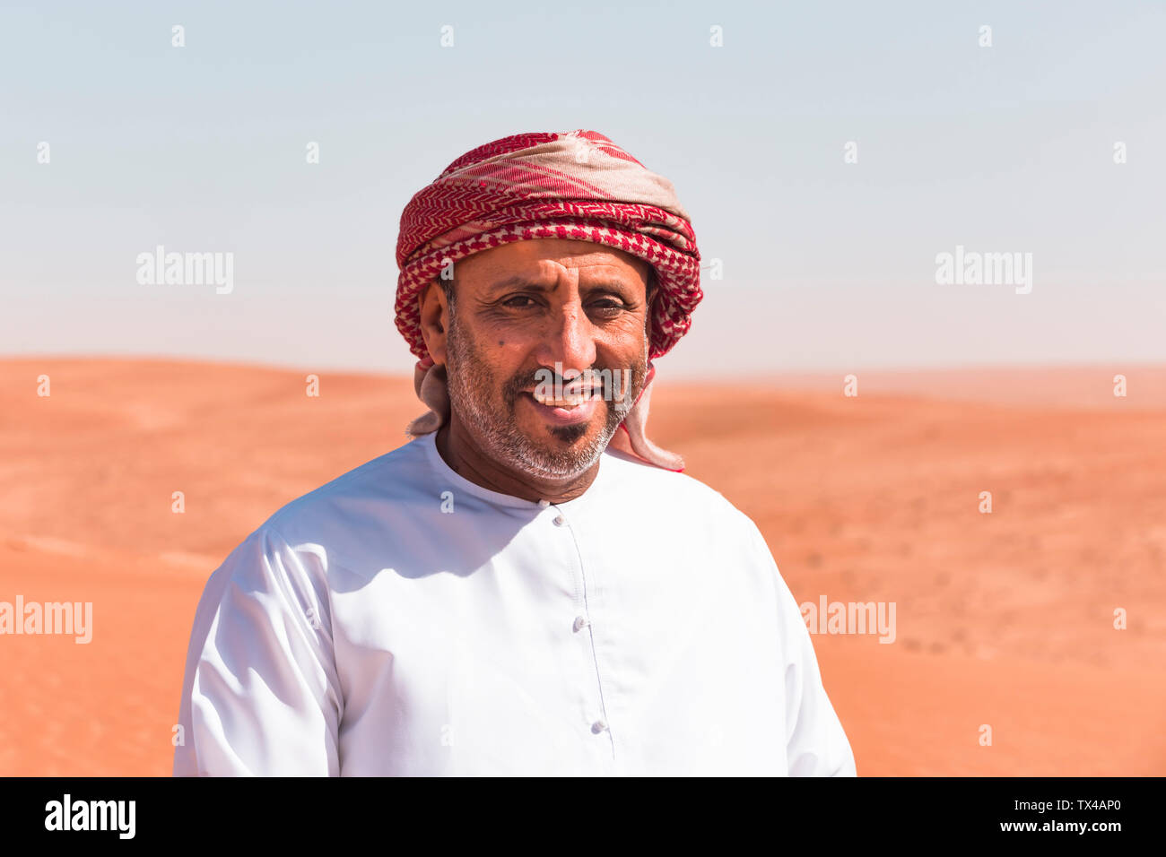 Bedouin in National dress standing in the desert, portrait, Wahiba Sands, Oman Stock Photo