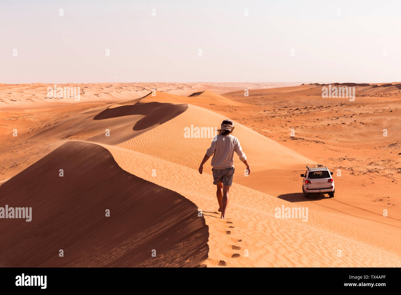 Man walking on a sand dune, Wahiba Sands, Oman Stock Photo Alamy