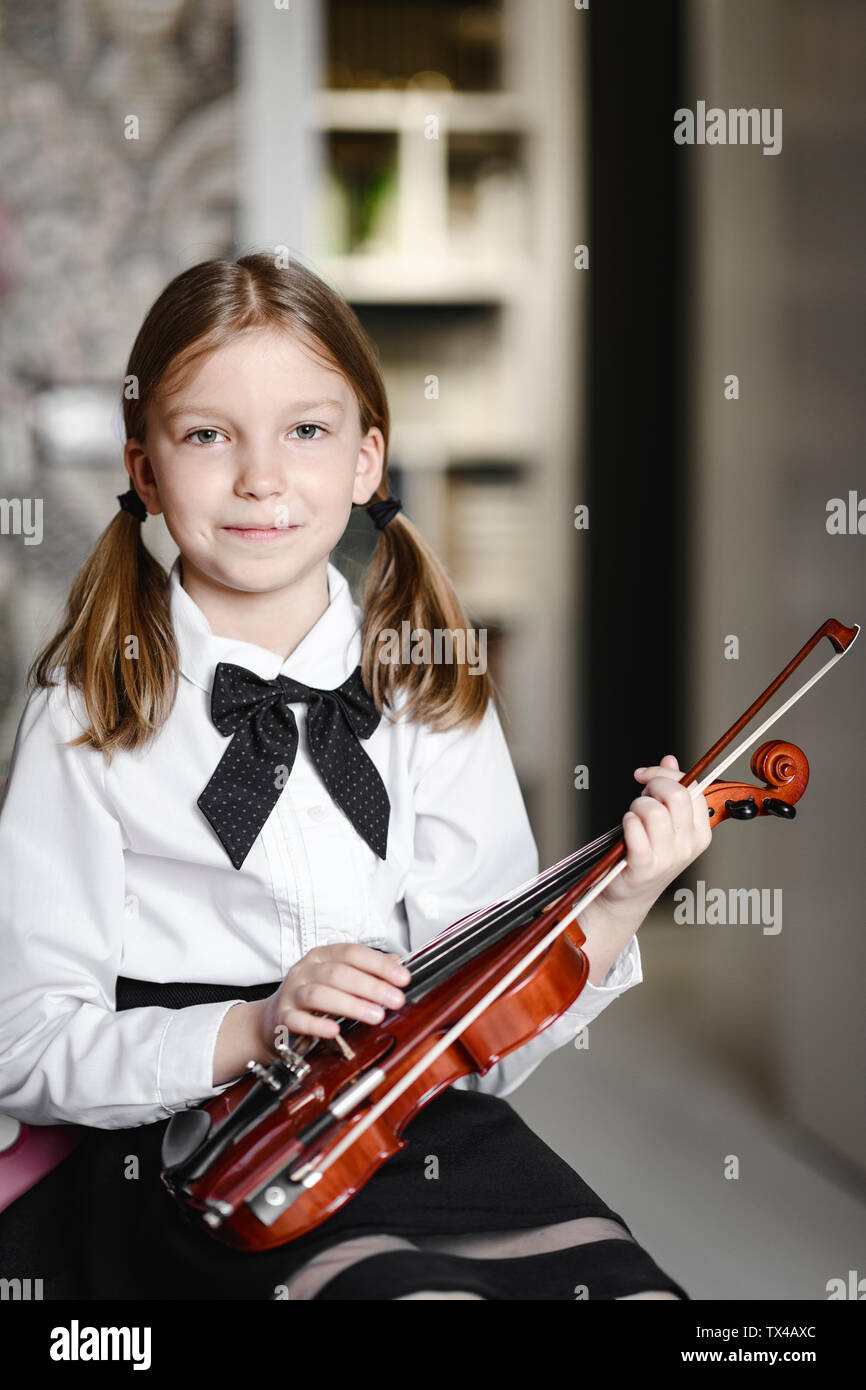 Portrait of a smiling girl with a violin at home Stock Photo