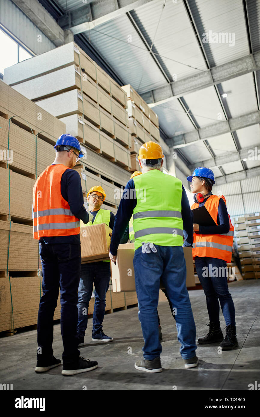 Workers talking in factory warehouse Stock Photo
