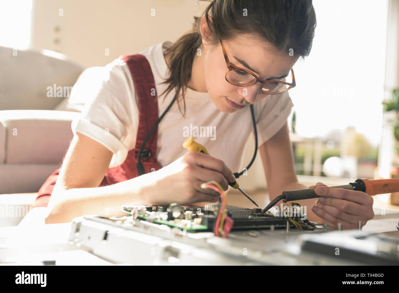 Young woman working on computer equipment at home Stock Photo