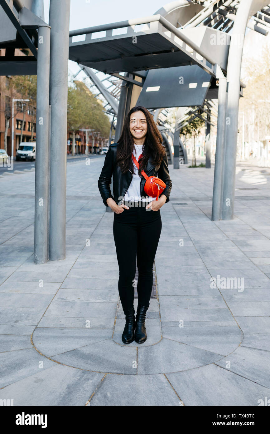 Happy young woman with a red hip bag in the city Stock Photo