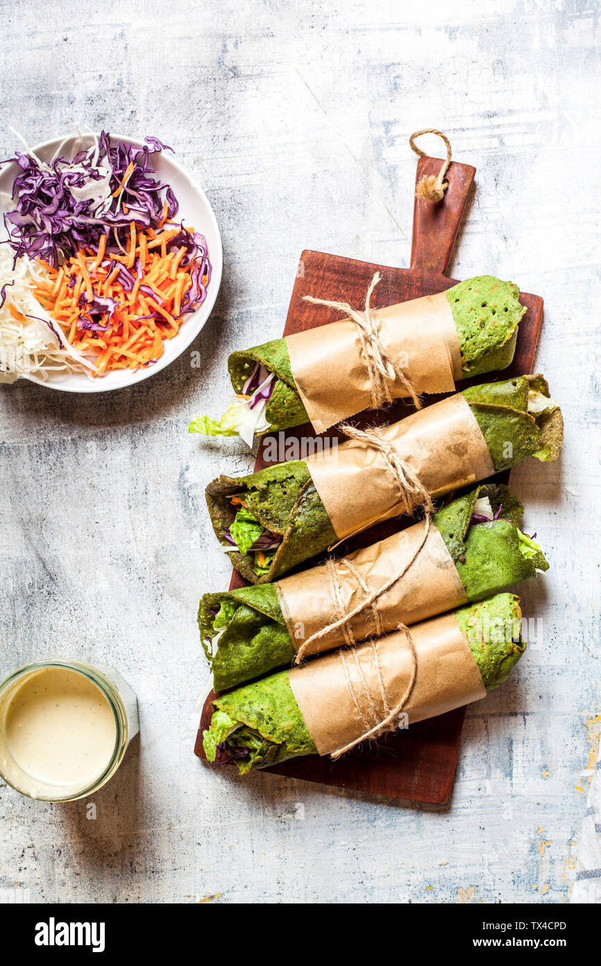 Lettuce wraps with spinach tortillas filled with lettuce, carrots and salad dressing Stock Photo