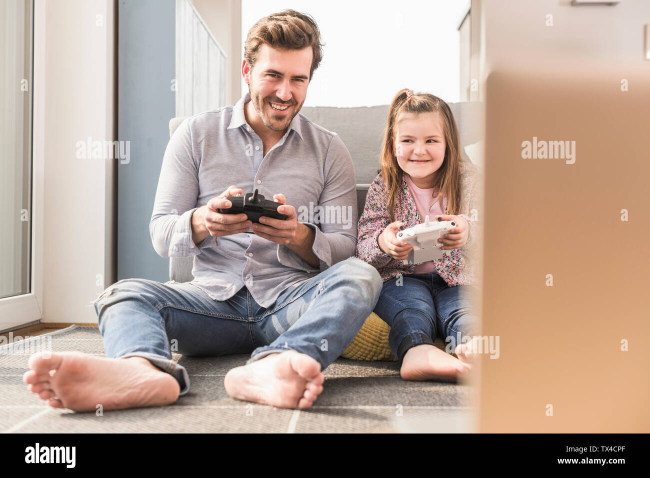 Young man and little girl playing computer game with gaming console Stock Photo
