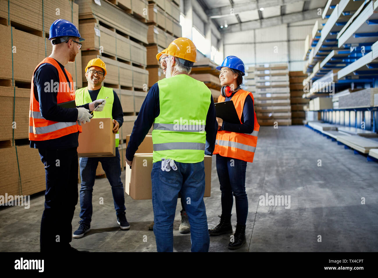 Workers talking in factory warehouse Stock Photo