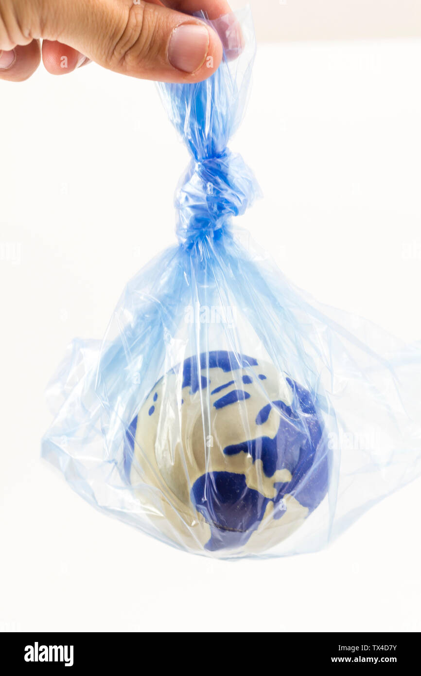 Human hand holding an earth globe inside a plastic bag, pollution and warming concept Stock Photo