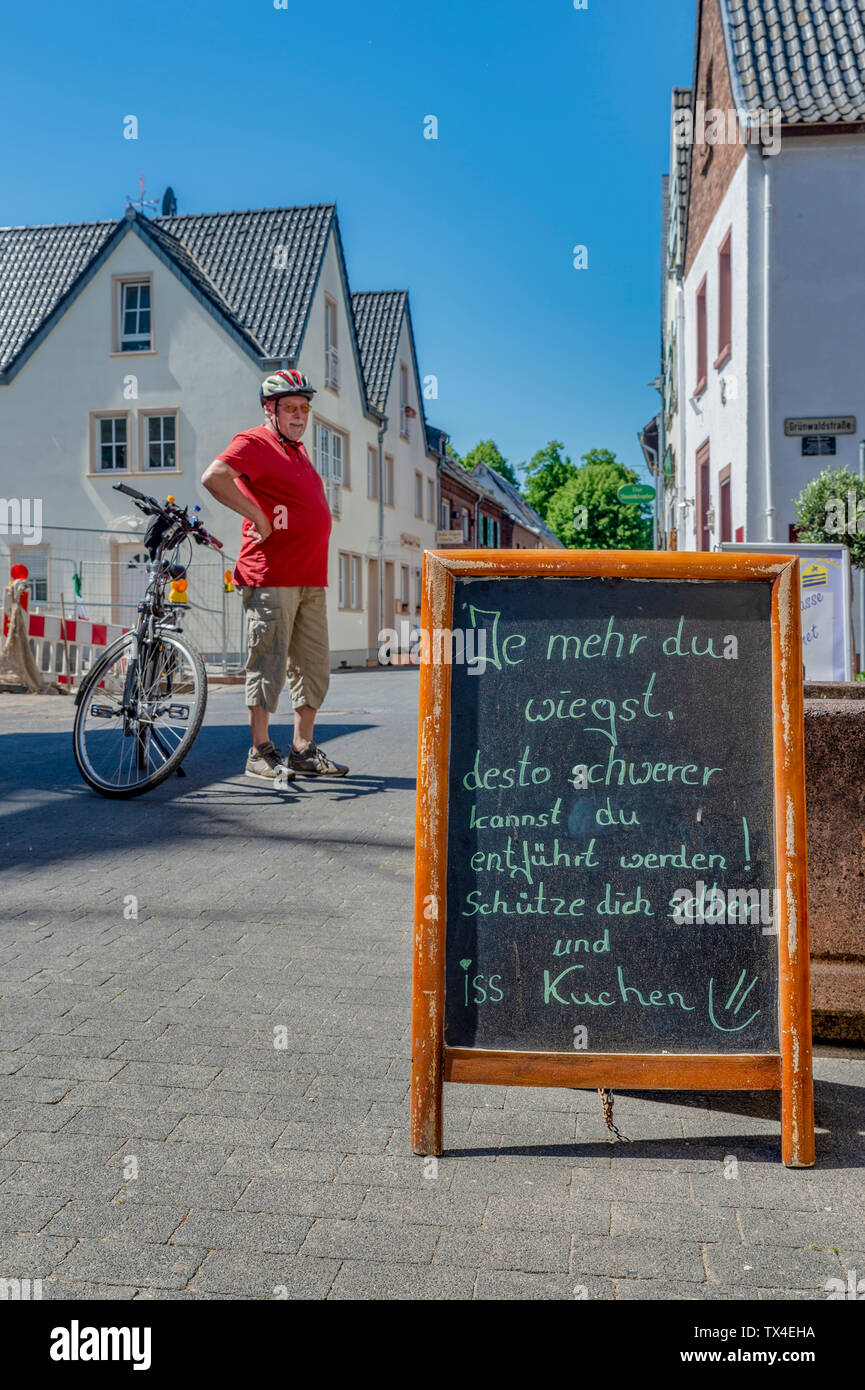 Germany, Zons, senior man with bicycle having a rest Stock Photo