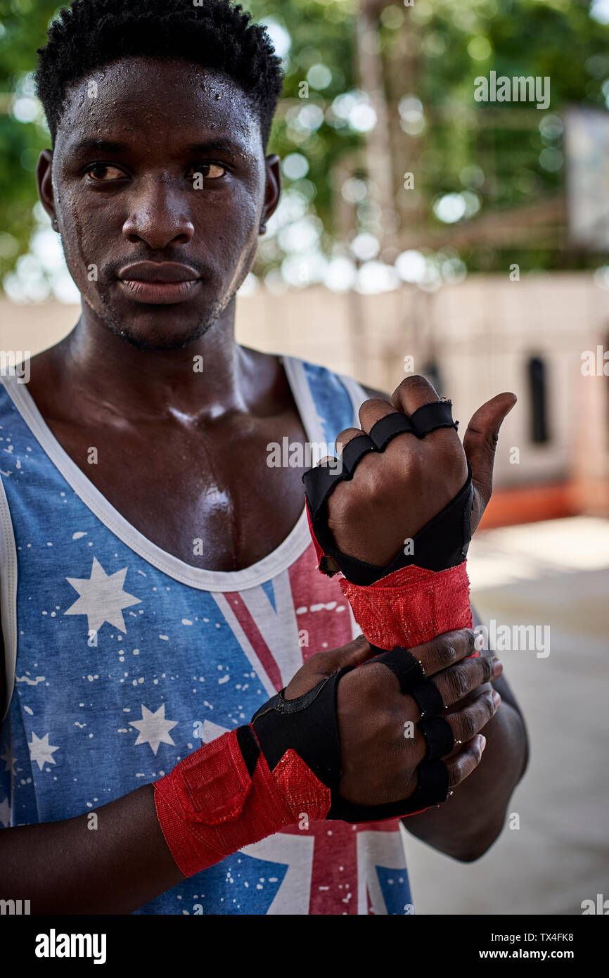 Portrait of serious boxer applying bandages Stock Photo