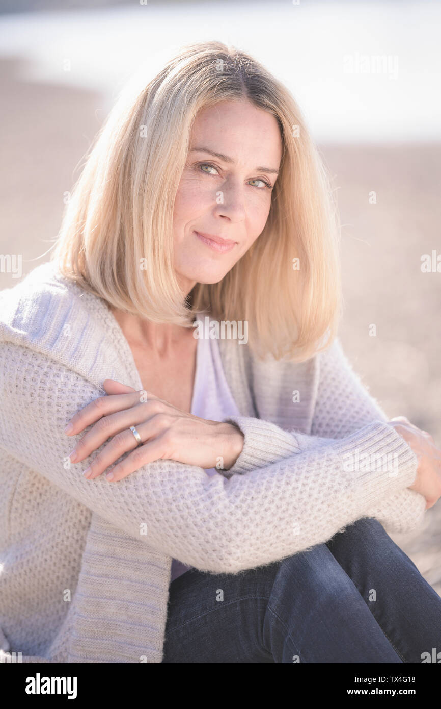 Portrait of smiling mature woman sitting outdoors Stock Photo - Alamy