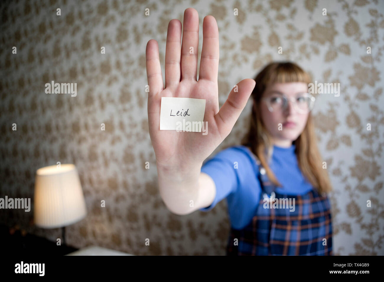 Student showing her hand, a note with the word suffer on her hand Stock Photo