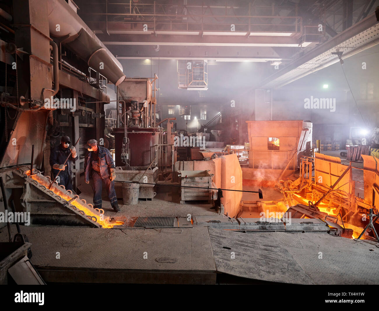 Industry, Workers controlling smelting process Stock Photo - Alamy