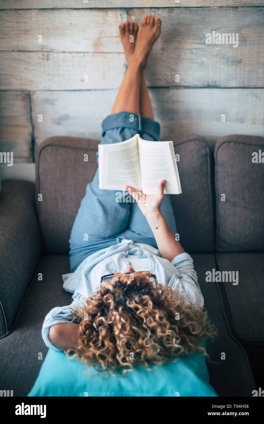 Woman lying on couch barefoot hi-res stock photography and images - Alamy