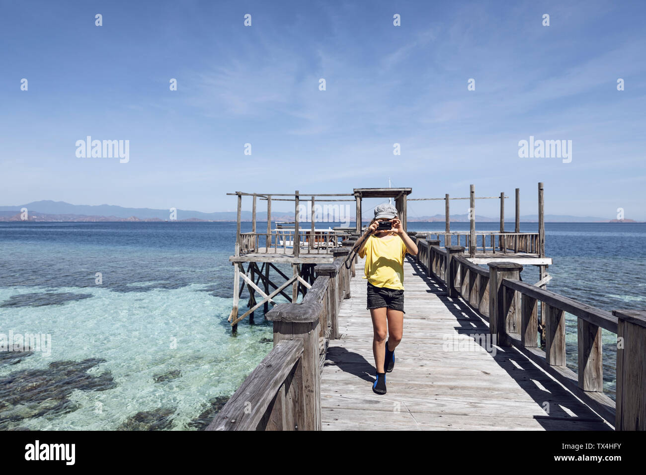 Indonesia, Komodo National Park, girl on a jetty taking a picture Stock Photo