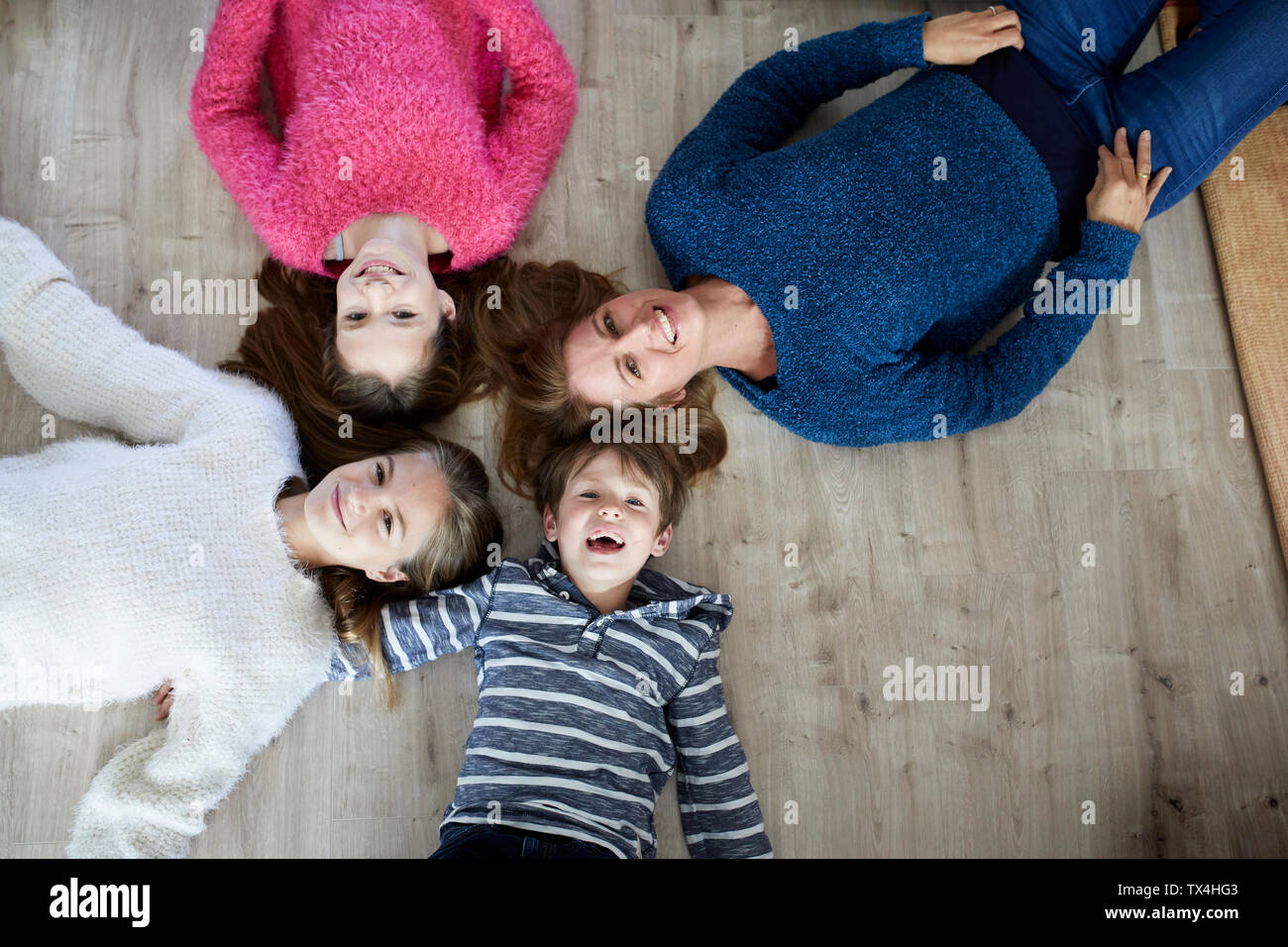 Happy family lying on the floor, laughing Stock Photo