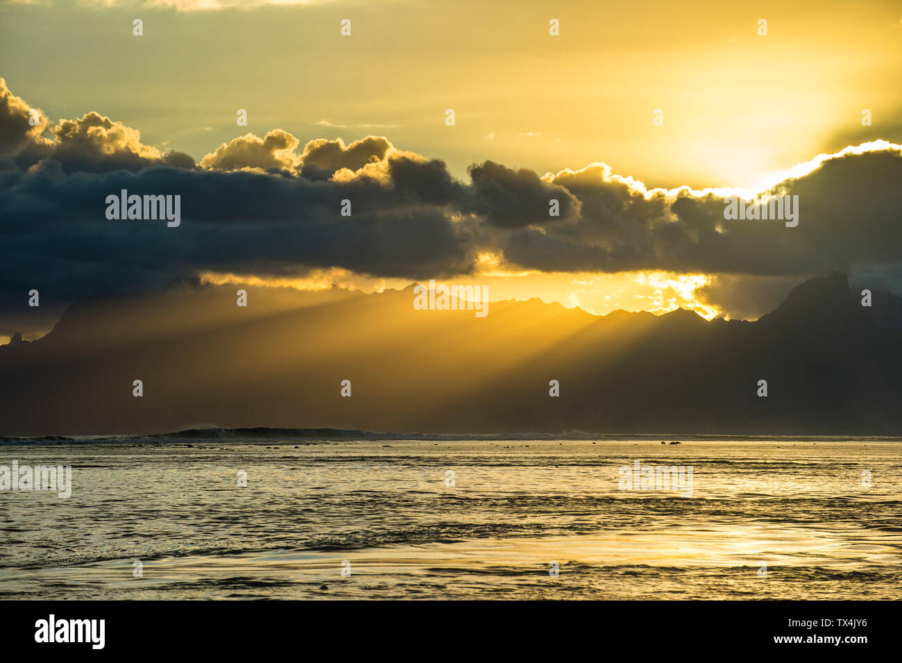 French Polynesia, Tahiti, sunrays breaking through the clouds over Moorea Stock Photo