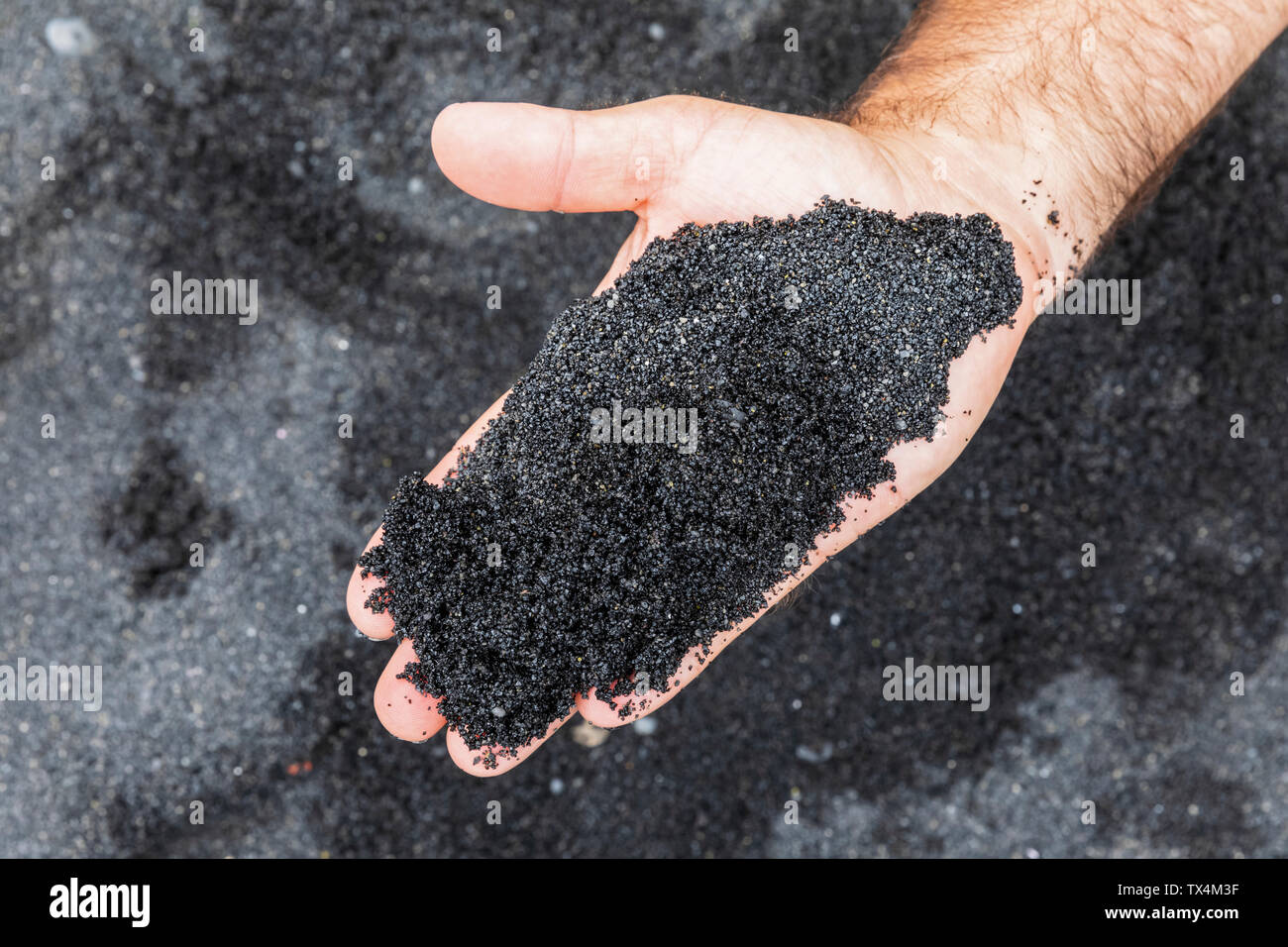 USA, Hawaii, Big Island, Hand holding black lava sand Stock Photo