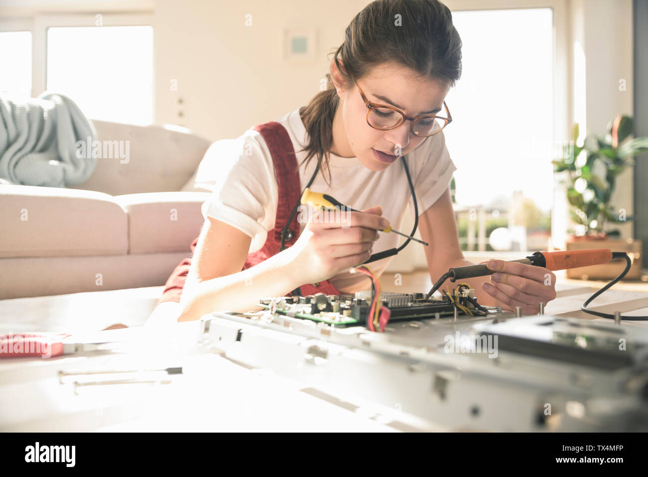 Young woman working on computer equipment at home Stock Photo