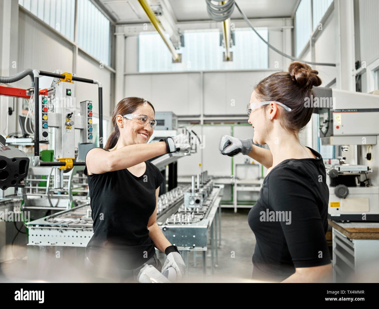 Two women at work, fist bump Stock Photo
