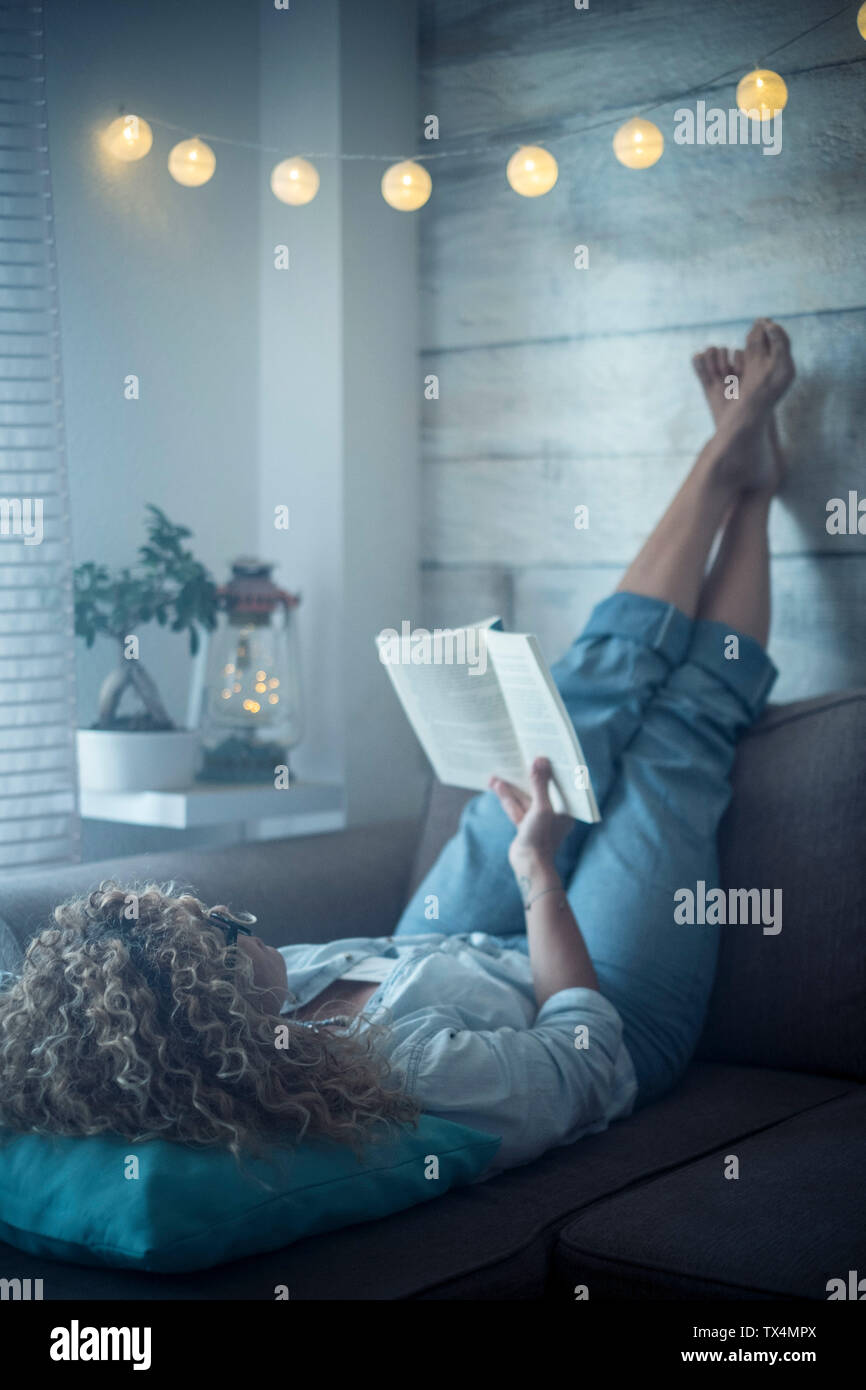 Woman lying on couch barefoot hi-res stock photography and images - Alamy