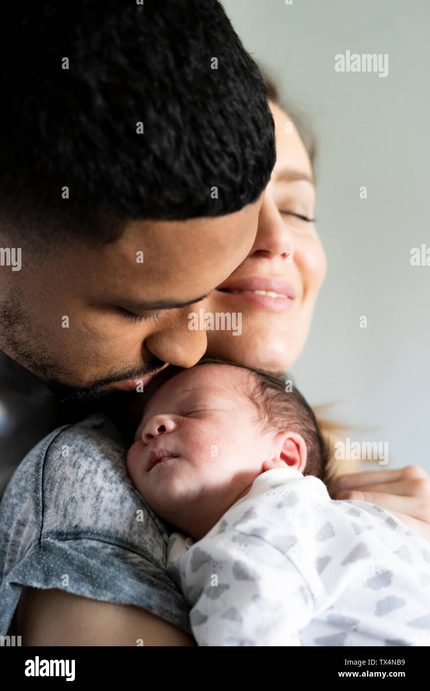 Parents cuddling with sleeping newborn baby Stock Photo Alamy